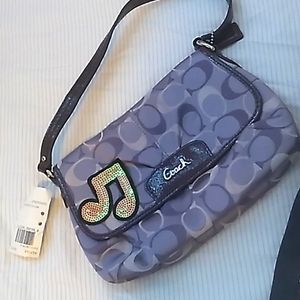 A purple Coach purse with a removable sticker.